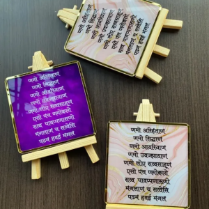 Acrylic Navakar Mantra frame (4 x 4.5 inch) with golden border, wooden stand, and available in two colours – Purple and White. Ideal for home or office decor.